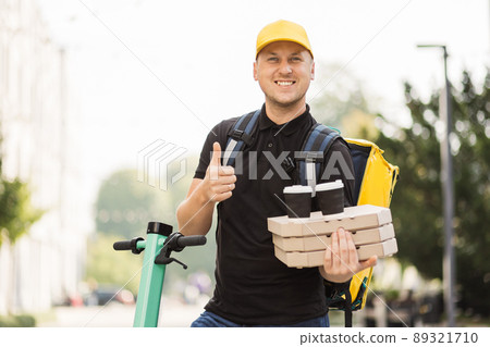 Delivery man in cap talking on smartphone. Delivery man in cap talking on smartphone. 89321710