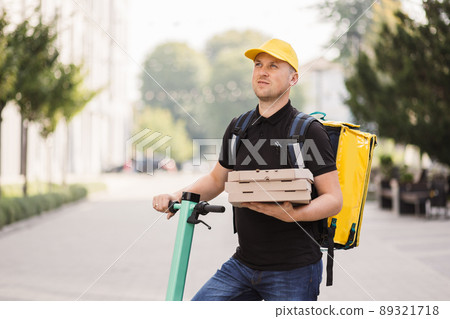 Male courier with pizza looking at camera Male courier with pizza looking at camera 89321718