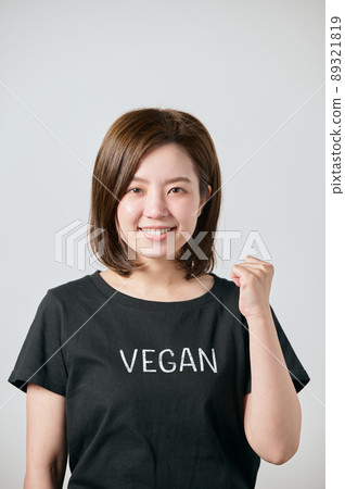 A young woman wearing a vegan T-shirt and doing a guts pose A young woman wearing a vegan T-shirt and doing a guts pose 89321819