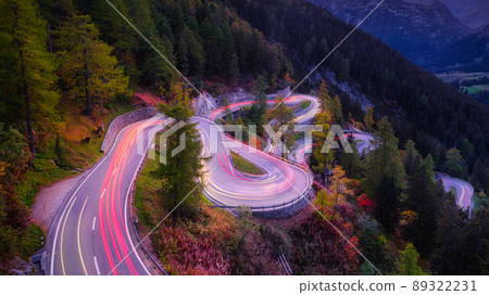Maloja pass, Switzerland. A road with many curves among the forest. A blur of car lights. Maloja pass, Switzerland. A road with many curves among the forest. A blur of car lights. 89322231