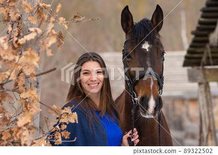 Close-up portrait of a horse and a beautiful girl of Slavic appearance, against the backdrop of a winter forest and an old farm Close-up portrait of a horse and a beautiful girl of Slavic appearance, against the backdrop of a winter forest and an old farm 89322502