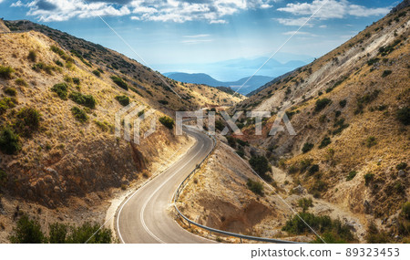 Aerial view of winding mountain road, blue sky with clouds at sunny day in summer 89323453