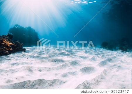 Underwater view of blue ocean with white sand and corals Underwater view of blue ocean with white sand and corals 89323747