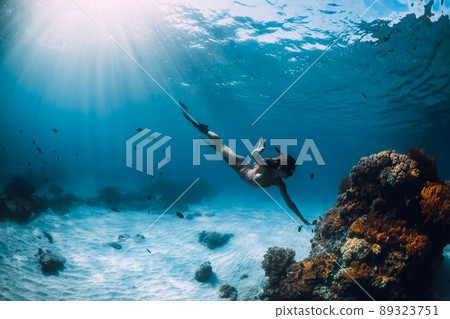 Beautiful girl freediver and corals. Freediving in ocean at Hawaii islands 89323751