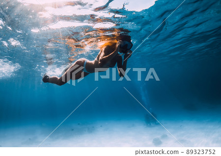 Young sexy woman swim with fins and mask in ocean. Underwater view 89323752