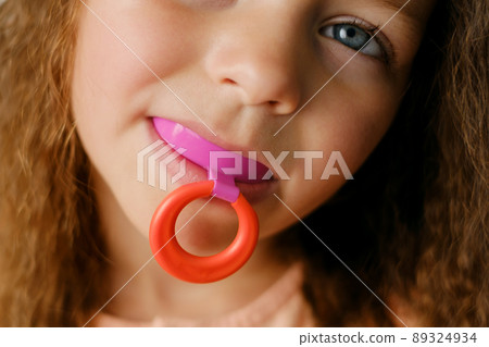 mouth guard - myofunctional trainer to eliminates mouth breathing habit, helps equalize the growing teeth and correct bite. mouthguard in the mouth of a girl close-up. A device for leveling teeth 89324934