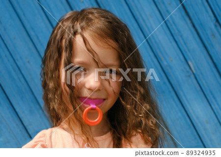 A cute girl with a vestibular hard mouthguard plate for correcting the bite of teeth in orthodontics. bruxism. Children's orthodontic mouthguard. myofunctional trainer. mouth breathing habit. 89324935
