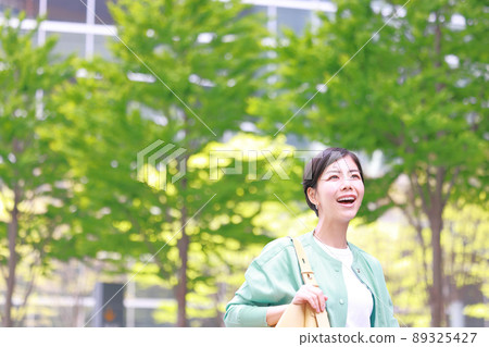 Fresh green city_Woman walking with a smile 3 89325427