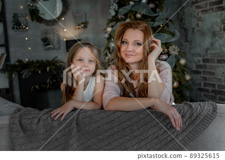 Head shot portrait beautiful young mother embrace little daughter supporting and caring sitting in living room at home spend time together. 89325615