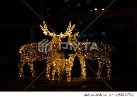 Christmas illumination deer, bokeh is lit in the city. On a black background. Christmas illumination deer, bokeh is lit in the city. On a black background. 89326796
