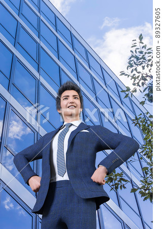 一位商人在樓街上把手搭在腰間，微笑著望著遠方，祝愿工作順利。 89327605
