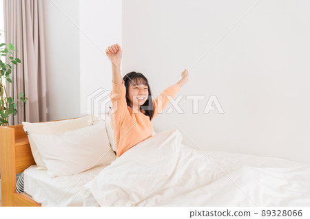 Girl waking up in bed 89328066