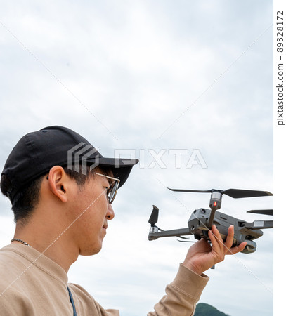 一個年輕人準備在藍天戶外拍攝無人機 89328172