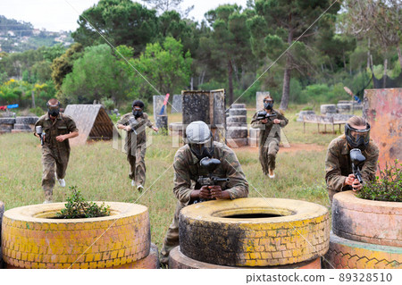 Two active opposing teams with guns playing paintball Two active opposing teams with guns playing paintball 89328510