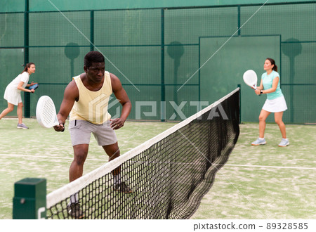 Positive young adult people playing paddle tennis 89328585