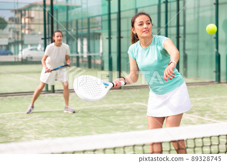 Young emotional women playing paddle tennis outdoors 89328745