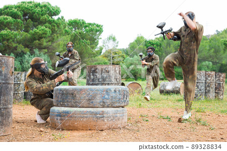 Two active opposing teams with guns playing paintball Two active opposing teams with guns playing paintball 89328834