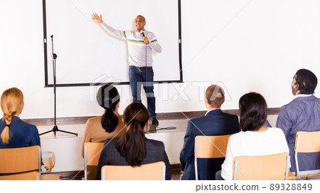 Male coach giving speech at conference hall 89328849