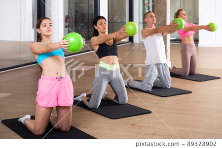 Young adults doing exercises with pilates ball 89328902