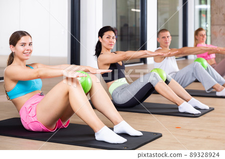 Young adults doing exercises with pilates ball Young adults doing exercises with pilates ball 89328924