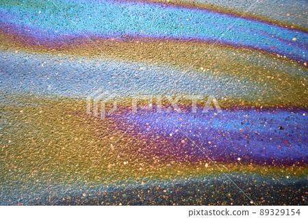 Oil stain on the asphalt, rainbow-shaped colored gasoline stains on an asphalt road 89329154