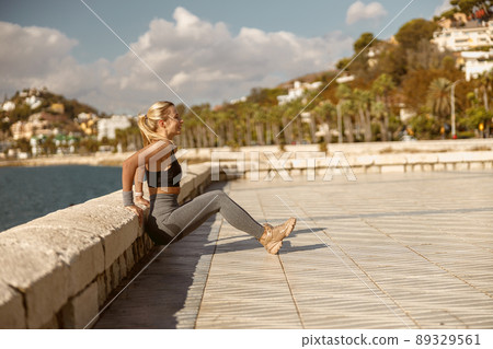 Morning workout of young female near sea Morning workout of young female near sea 89329561