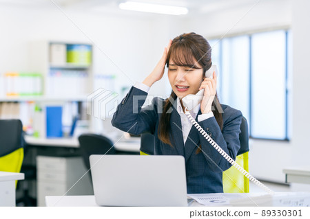 支持電話的辦公室的女商人 支持電話的辦公室的女商人 89330301