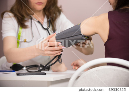 cosmetology beauty clinic. doctor checking patient's blood pressure, close-up of the patient's hand cosmetology beauty clinic. doctor checking patient's blood pressure, close-up of the patient's hand 89330835