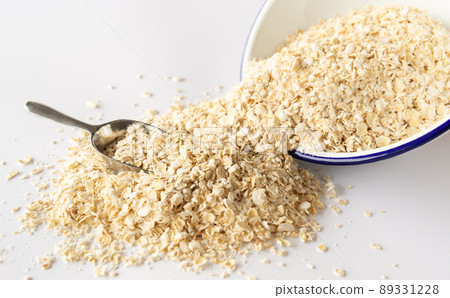 Crushed oatmeal spilling from the bowl Crushed oatmeal instant bowl Crushed oatmeal spilling from the bowl Crushed oatmeal instant bowl 89331228