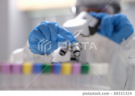 Scientist in laboratory holding syringe with liquid vaccines 89331324