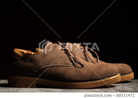 Side view of brown shoes with laces on a black background Side view of brown shoes with laces on a black background 89331472
