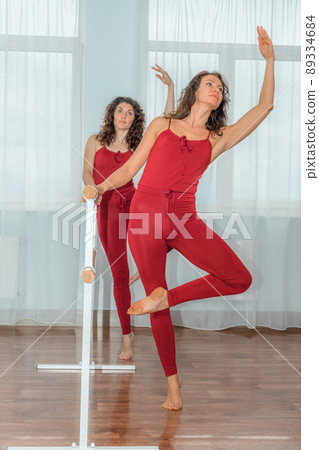 I train with a friend. Two young women train together in a bright training room near a choreographic machine. I train with a friend. Two young women train together in a bright training room near a choreographic machine. 89334684