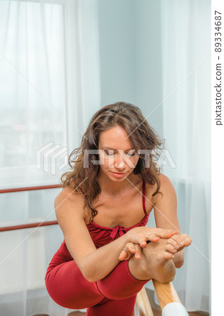 A choreographer in a red jumpsuit is engaged near the machine, in the choreographic hall. A choreographer in a red jumpsuit is engaged near the machine, in the choreographic hall. 89334687