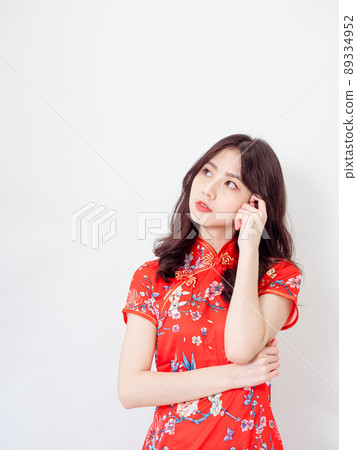 Portrait of Young asian woman wearing traditional cheongsam qipao dress thinking with hand on head isolated over white background. Portrait of Young asian woman wearing traditional cheongsam qipao dress thinking with hand on head isolated over white background. 89334952