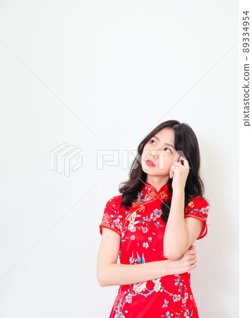 Portrait of Young asian woman wearing traditional cheongsam qipao dress thinking with hand on head isolated over white background. Portrait of Young asian woman wearing traditional cheongsam qipao dress thinking with hand on head isolated over white background. 89334954