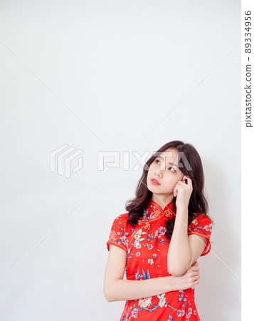 Portrait of Young asian woman wearing traditional cheongsam qipao dress thinking with hand on head isolated over white background. Portrait of Young asian woman wearing traditional cheongsam qipao dress thinking with hand on head isolated over white background. 89334956