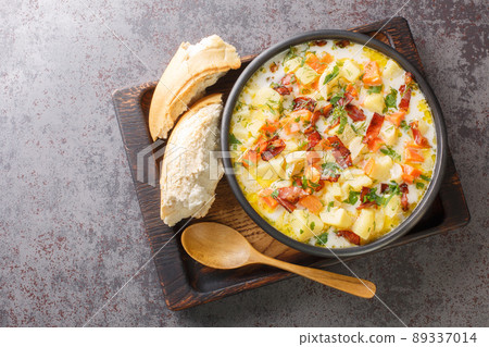 Homemade vegetable potatoes soup with smoked bacon closeup on the wooden tray. Horizontal top view 89337014