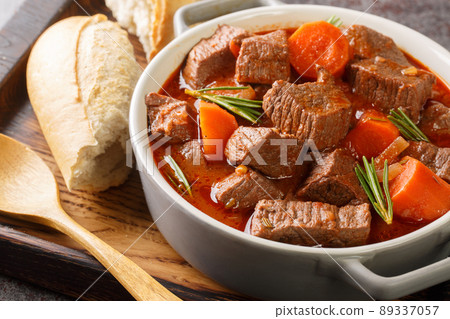 French beef stew in red wine known as daube de boeuf Provencal closeup in the wooden tray. Horizontal French beef stew in red wine known as daube de boeuf Provencal closeup in the wooden tray. Horizontal 89337057