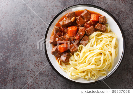 Daube de Boeuf Provencale slow cooked Rich Beef Stew with noodles closeup in the plate. Horizontal top view Daube de Boeuf Provencale slow cooked Rich Beef Stew with noodles closeup in the plate. Horizontal top view 89337068