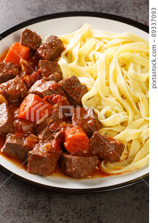Daube Provencal classic French stew beef is slow simmered to tenderness served with noodles closeup in the plate. Vertical Daube Provencal classic French stew beef is slow simmered to tenderness served with noodles closeup in the plate. Vertical 89337093