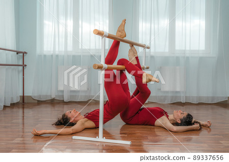 I train with a friend. Two young women train together in a bright training room near a choreographic machine. 89337656