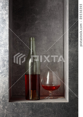 Glass and vintage bottle of brandy. 89338393