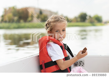 Little girl dressed life vest ride pleasure boat on city river Sunny summer day Caucasian female child swimming on boat Little girl dressed life vest ride pleasure boat on city river Sunny summer day Caucasian female child swimming on boat 89339860