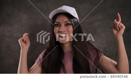 Happy Asian woman against a grey background 89340546