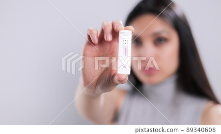 Woman holding a Corona Covid-19 Test with negative result Woman holding a Corona Covid-19 Test with negative result 89340608