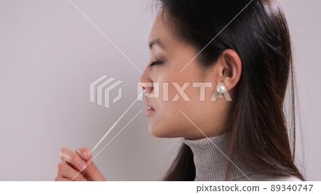 Young woman takes a sample from her nose for a corona test 89340747