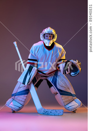 Portrait of concentrated boy, child, goalkeeper, training hockey game isolated over purple background in neon light Portrait of concentrated boy, child, goalkeeper, training hockey game isolated over purple background in neon light 89340831