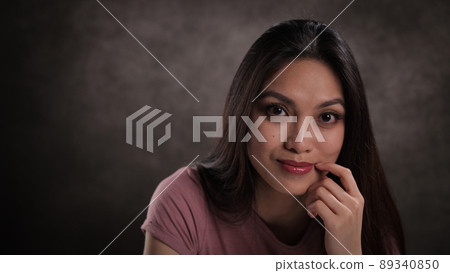 Close-up of a young woman with a satisfied facial expression Close-up of a young woman with a satisfied facial expression 89340850