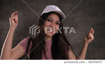 Happy Asian woman against a grey background 89340857