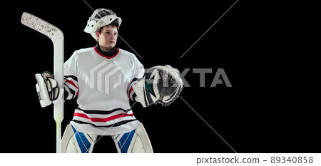 Portrait of young by, teen hockey player, goalkeepr training, posing isolated over black studio background Portrait of young by, teen hockey player, goalkeepr training, posing isolated over black studio background 89340858